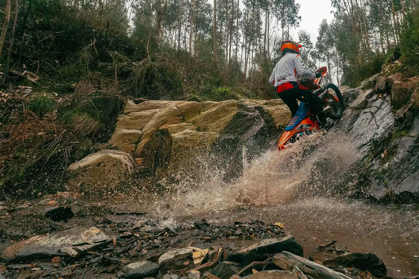 Enduro riders on a trail beside a river in Portugal