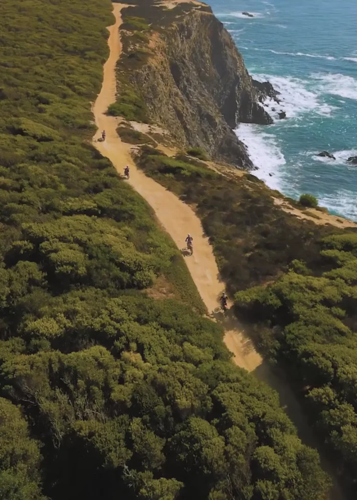 Dirt bike riders on a coastal trail along the Atlantic coast of Portugal